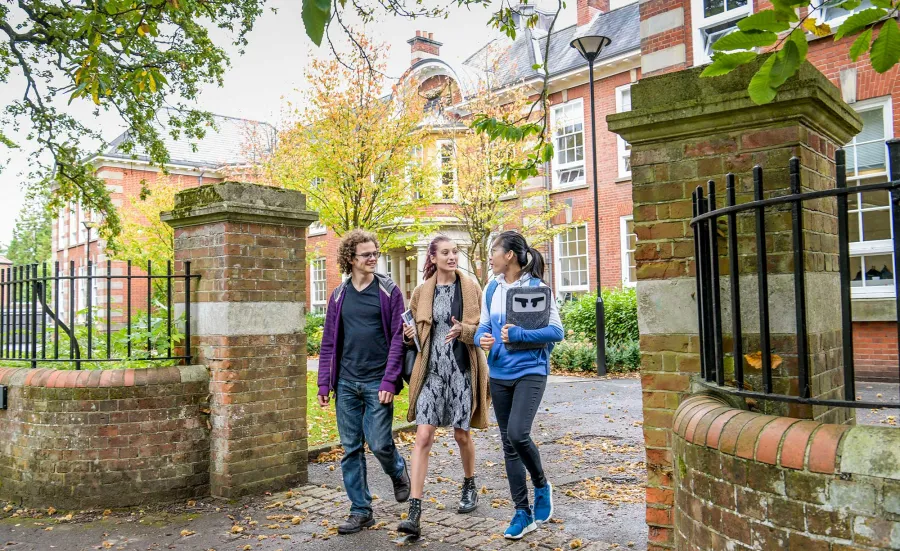 Students walking through gates outside the impressive buildings of Avenue Campus.