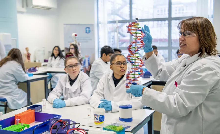 School children in lab coats learning in the Life Lab.