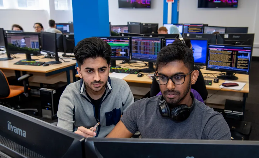 Student and tutor looking at business trading screen.