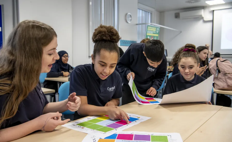 School pupils discussing classroom activity sheet