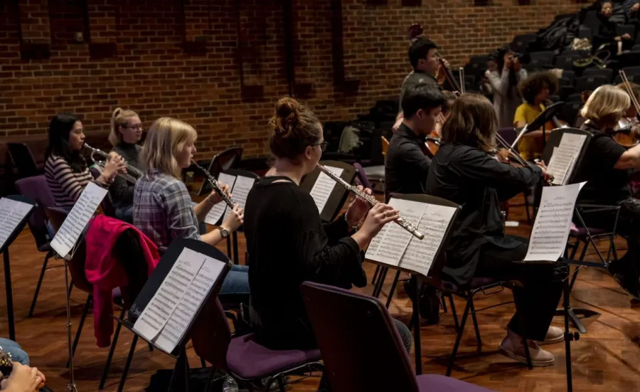 Music students playing strings and brass perform live in Turner Sims concert hall