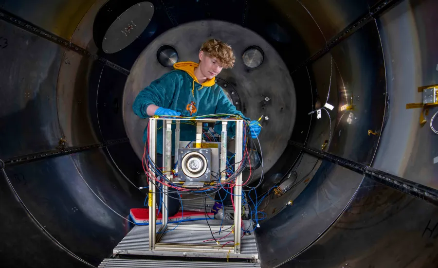 A student works on an experiment in the electric propulsion lab