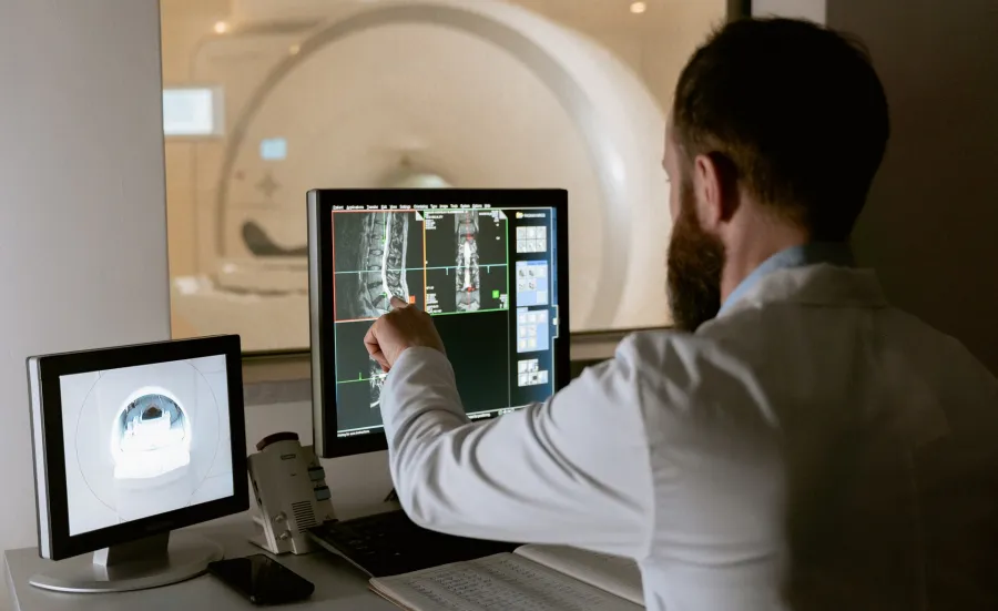 Healthcare professional monitoring an MRI scan and viewing the results