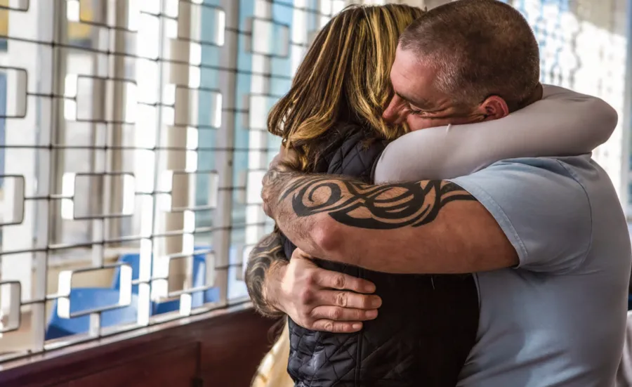 A man and woman hug tightly