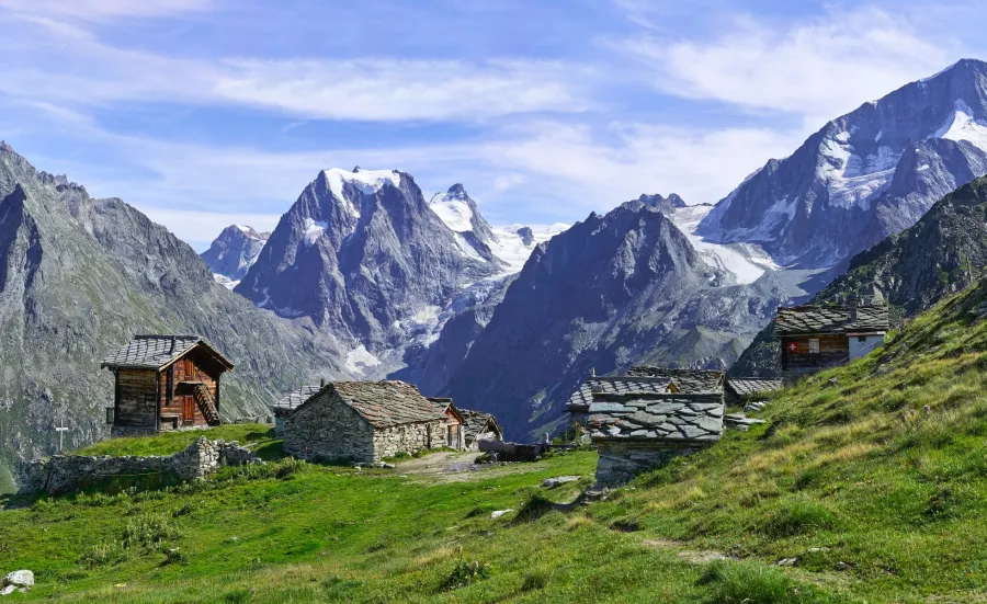 Looking across green fields towards the peaks of the Arolla mountains