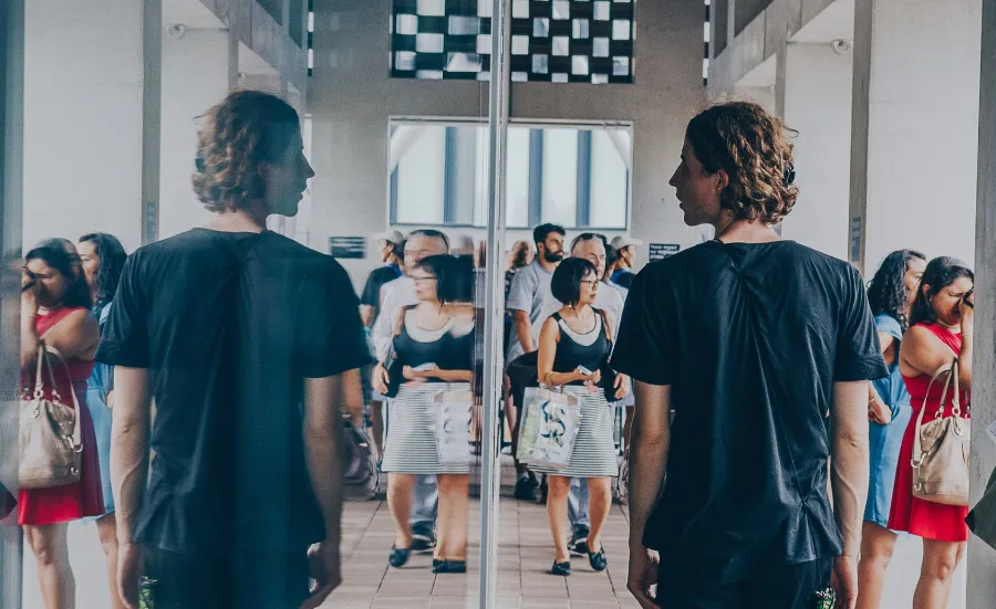 Man looking at his reflection in a window