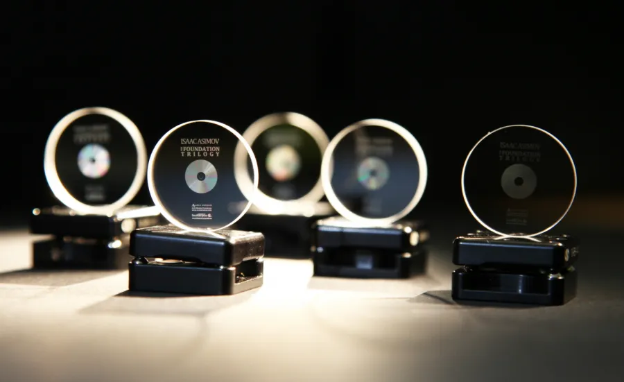 A row of 5 memory crystals on stands, softly lit against a black background. They have been imprinted with copies of the Foundation trilogy by Isaac Asimov.