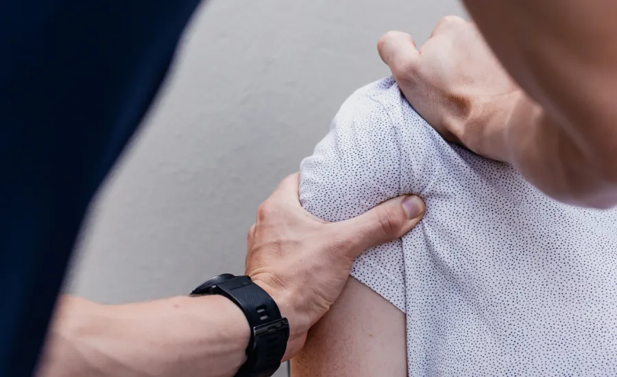 Unsplash image of a physiotherapist manipulating a patient's shoulder muscles