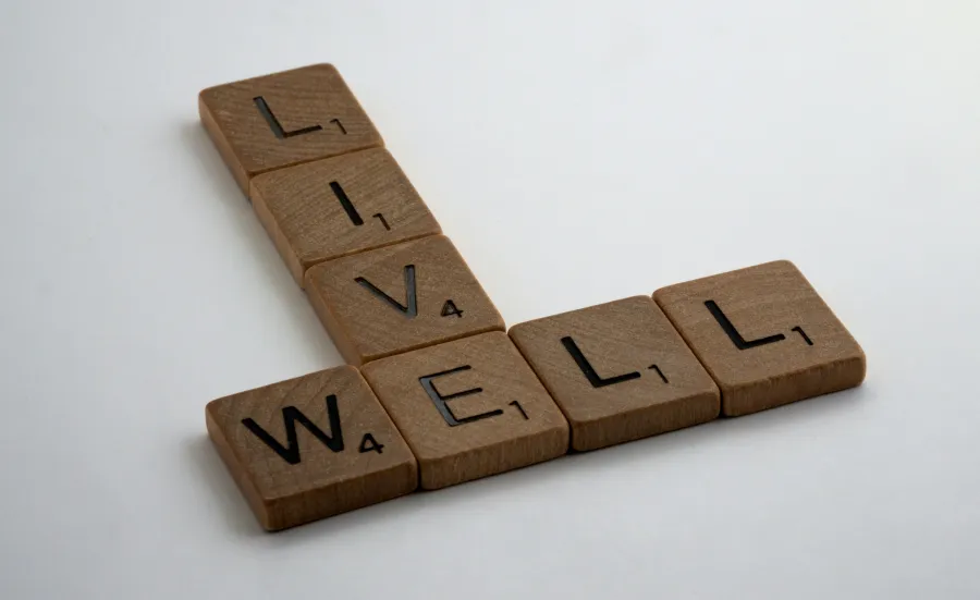 Wooden Scrabble pieces spelling out the words Live Well