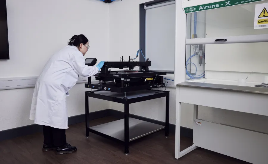 A woman researcher using a machine at the e-textile laboratory