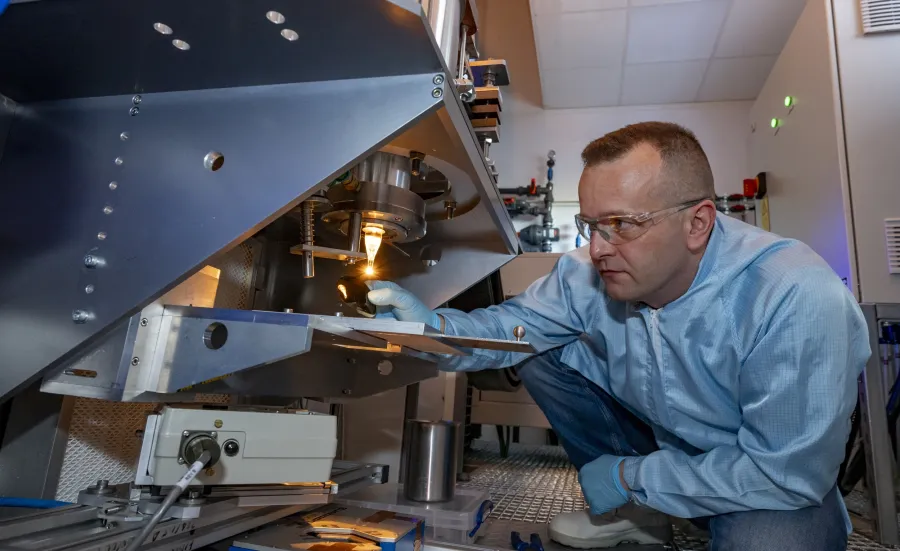 A man working with fibre drop out of the furnace