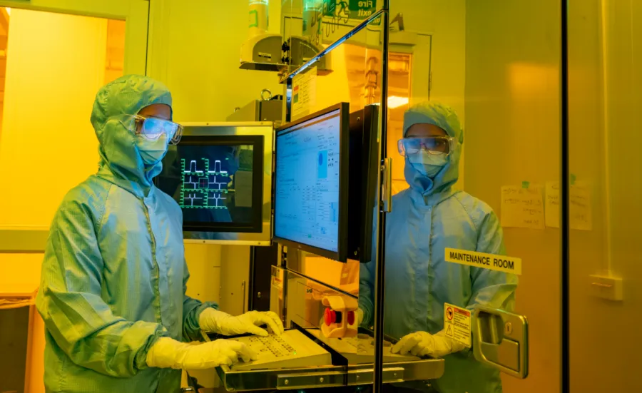 A researcher in a cleanroom suit and wearing a protective glasses, uses the electron beam lithography (EBL) facility