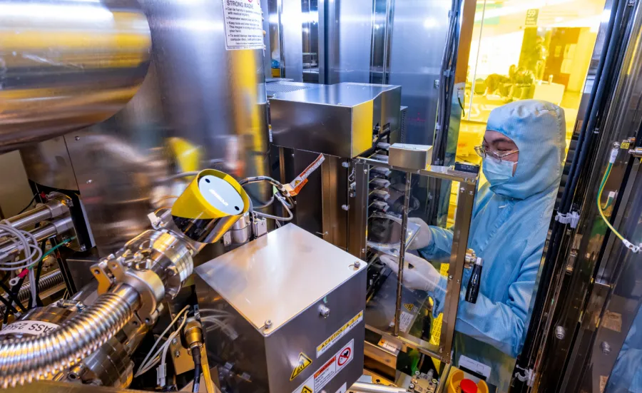 A researcher in a cleanroom suit inside the electron beam lithography (EBL) tool - the JBX-8100 G3 