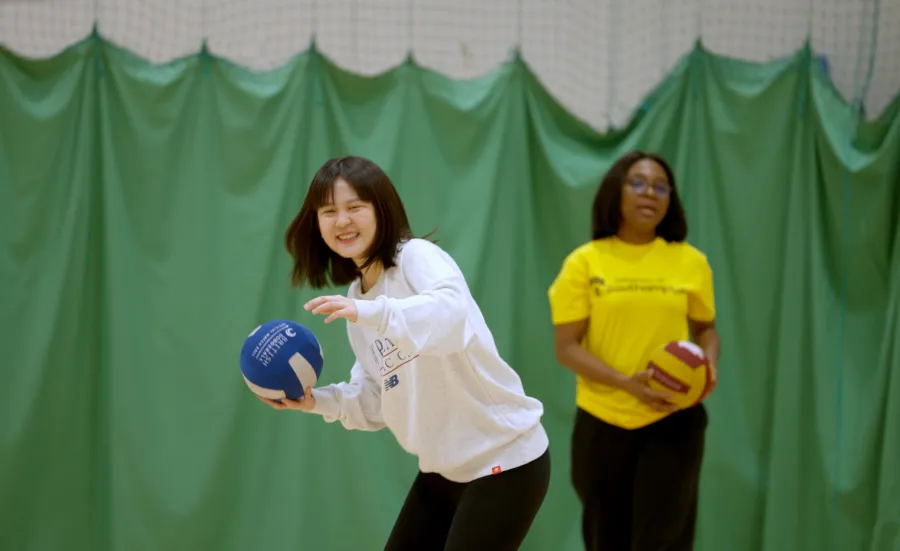 Women practising volleyball throws