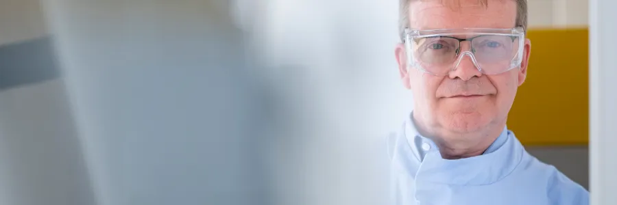 Scientist wearing safety goggles whilst working with lab equipment