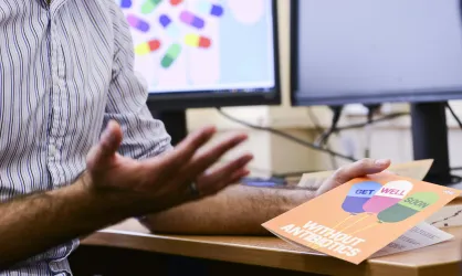 A hand holding a get well without antibiotics card