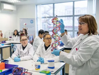 School children in lab coats learning in the Life Lab.