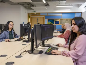 A group of economics students at work in the financial suite