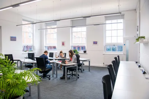 Students studying at desks in a bright, airy room.