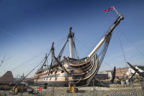 An exterior view of HMS Victory docked at Portsmouth Historic Dockyard.