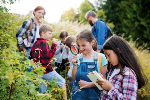 A group of children and two adults in the countryside