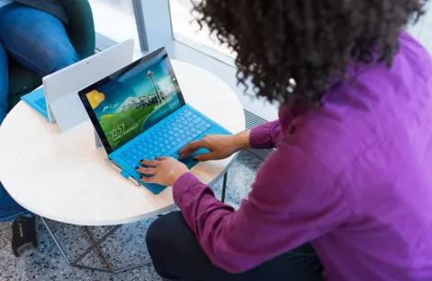 One woman working on her laptop on a small table