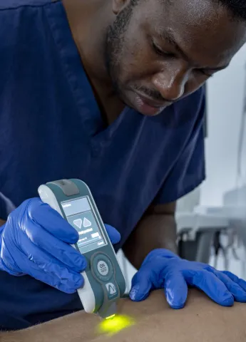 A PhD researcher measuring the tissue tone of a volunteer in the Pressure Lab