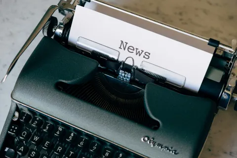 Old style typewriter with News typed on a sheet of paper