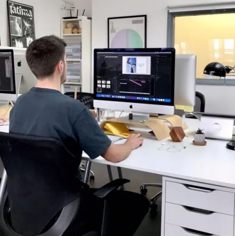 A person is sitting at a desk in front of a computer, facing away from the camera.