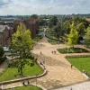 Aerial view of campus buildings, trees and courtyard area on a sunny day.