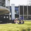 Students sitting on the grass on a sunny day, outside Winchester School of Art.