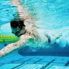 Man swimming under water in a swimming pool.