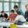 College students huddled around laptop for a group task