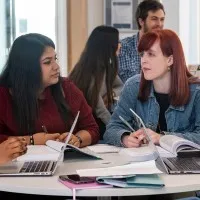 four undergraduate accelerated law students discussing round a table