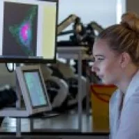 Female biochemistry student in a lab coat and in a lab