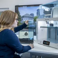 A student inspecting the finished construction of her latest 3D printed object.