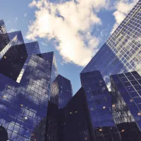 Low-angle view of city office buildings reflecting the sky