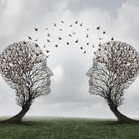 Two head shaped trees with birds flying to each other as a metaphor for teamwork 