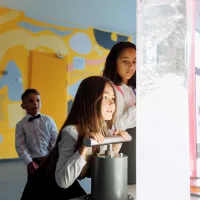 Children looking at coloured liquids in large tubes