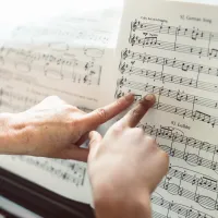 2 fingers pointing at sheet music on a piano