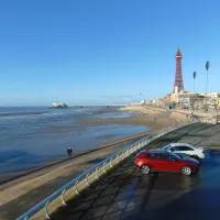 View of Blackpool Tower, beach and coastal defences on a sunny day.