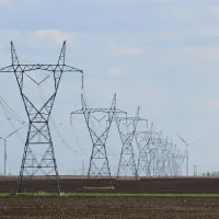 Transmission towers and wind turbines on a field